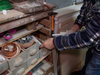 Prende una delle strisce in marmo colorato che conserva in apposite scatole in legno...